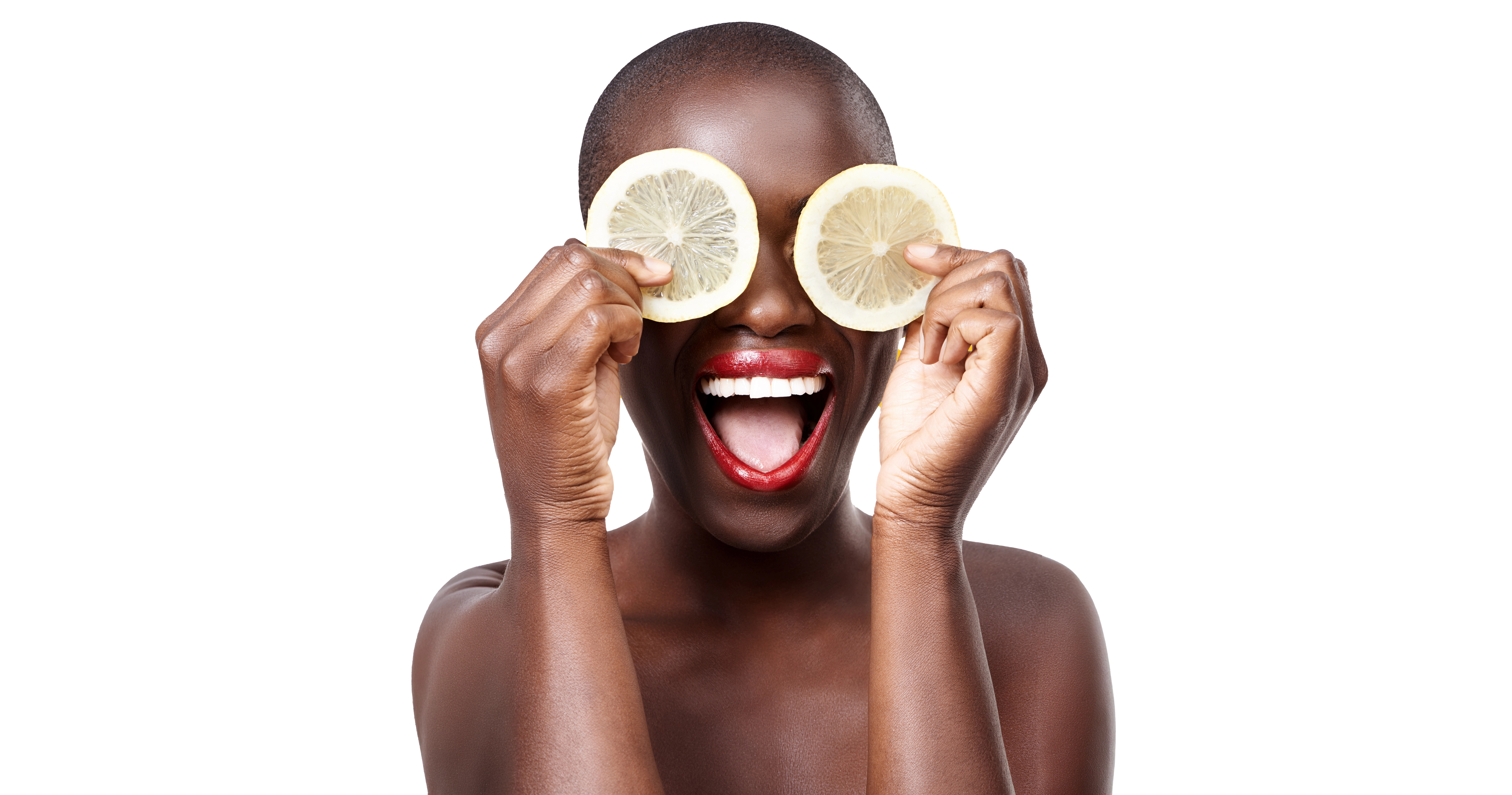 Woman holding lemon slices up to her eyes